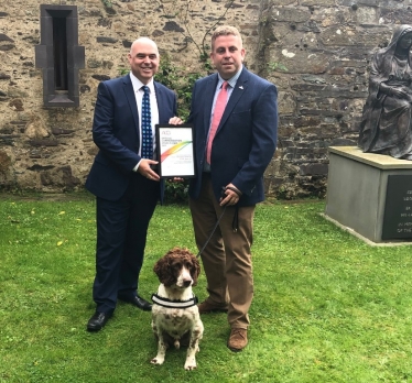 Paul Davies AM is pictured with Stuart Phillips and Scamp from B.W.Y. Canine Ltd.,/ Paul Davies AC gyda Stuart Phillips a Scamp o B.W.Y. Canine Ltd.,